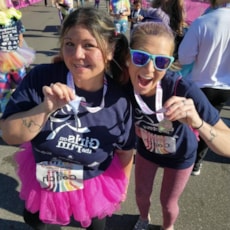Two Girls on the Run participants smile while showing off 5K medals